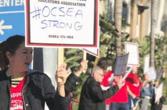 People holding signs outside in support of OCSEA