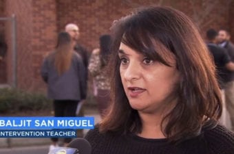 Person standing outside being interviewed with people standing in back of her