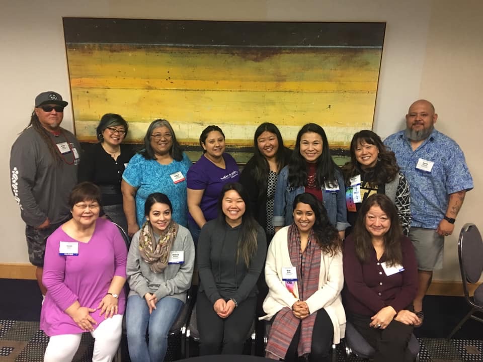 A group of Pacific Asian American Caucus sitting in two rows smiling