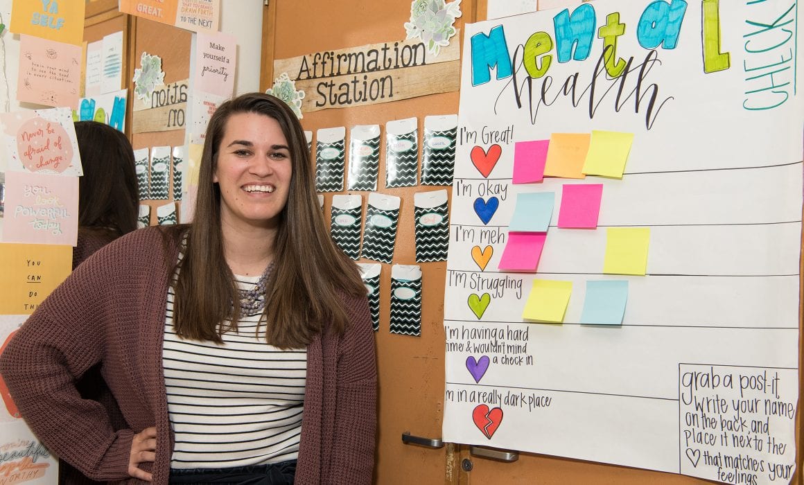 Teacher standing n front of mental health sign