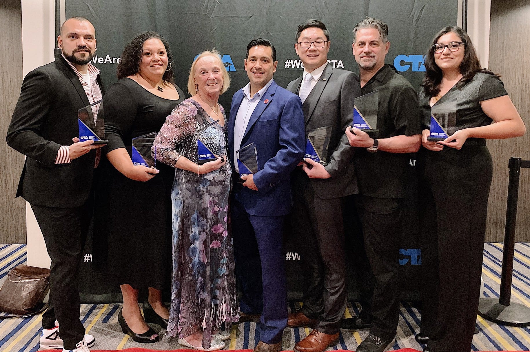 Seven people standing and holding awards