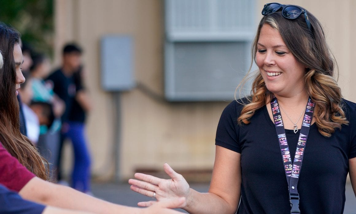 Teacher giving students a welcome high five