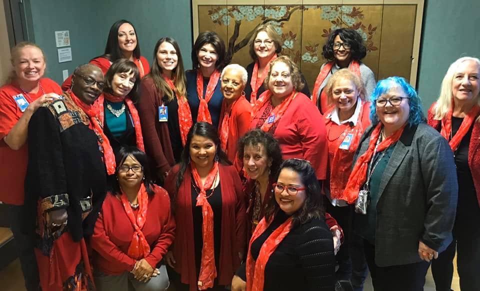 A group of members of the CTA Women's Caucus stand together wearing red