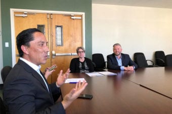 Man talking to others sitting around a conference table