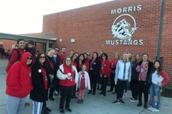 People standing in picture smiling outside of Morris Mustangs school