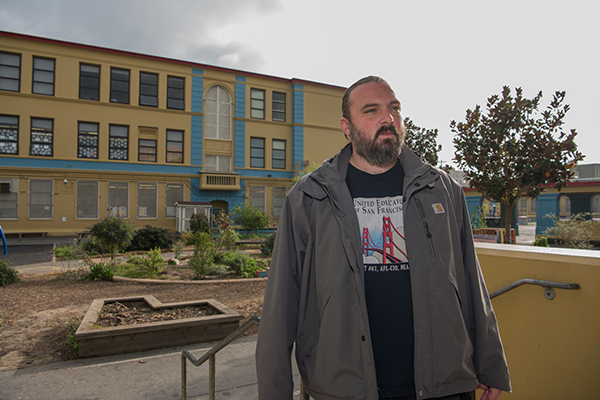 Nick Chandler standing in front of school