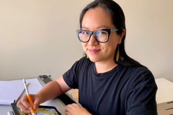 Audrey Chan at drawing table creating poster