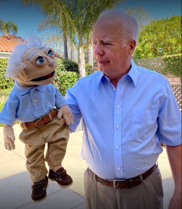 Man holding puppet that looks like him.