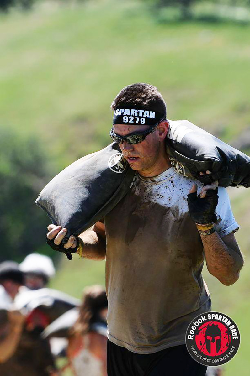 Daniel Diaz-Romero carrying heavy sacks in race.