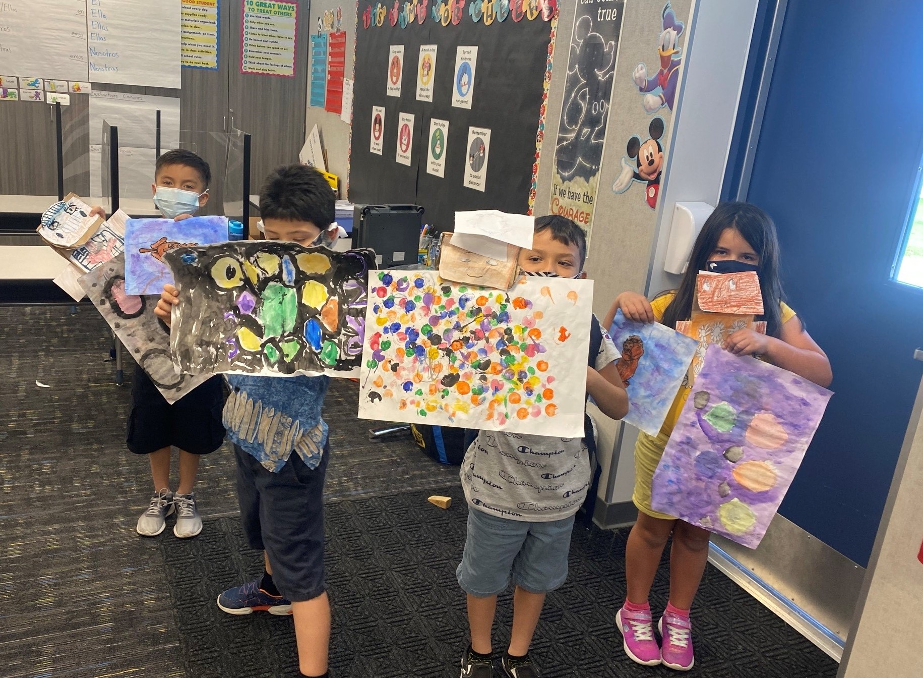 David Cuesta's students showing their artwork.