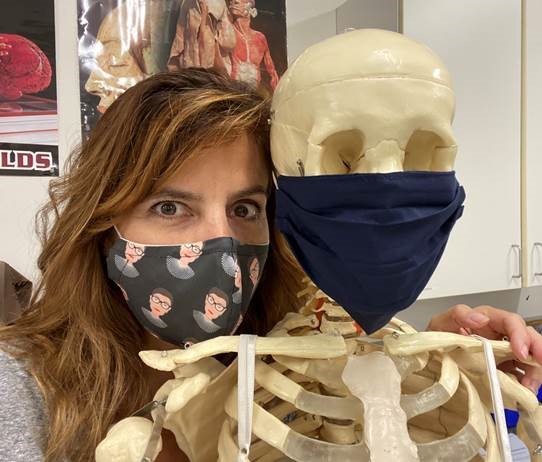Christine Karlberg, masked, with a skeleton, also masked.