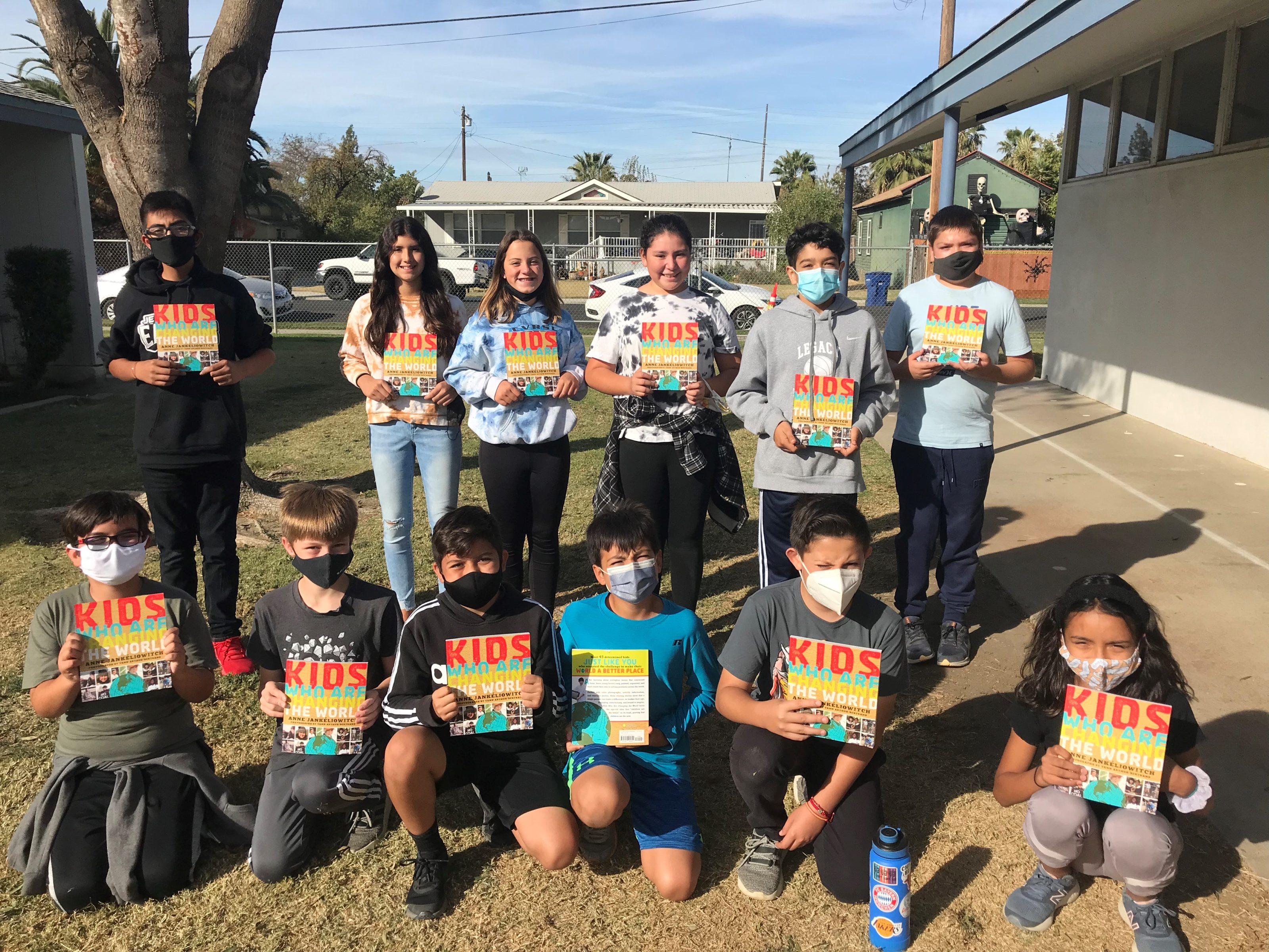 Group of students holding copies of the book "Kids Who Are Changing the World" 