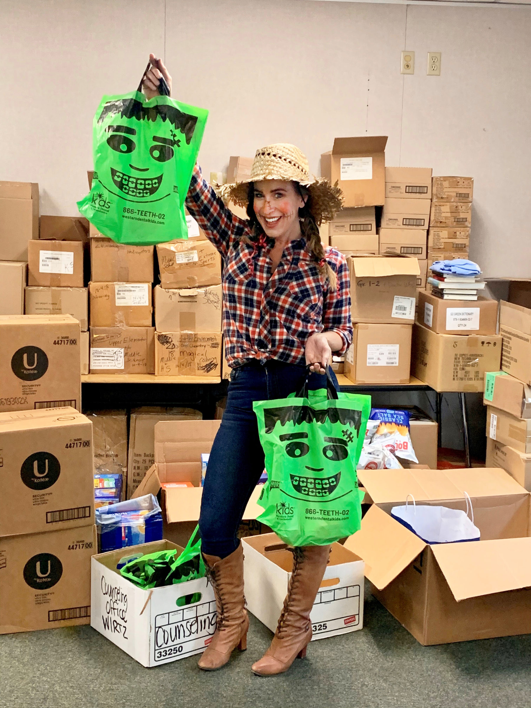 Julie White, surrounded by shelves of boxes, holding Halloween bags