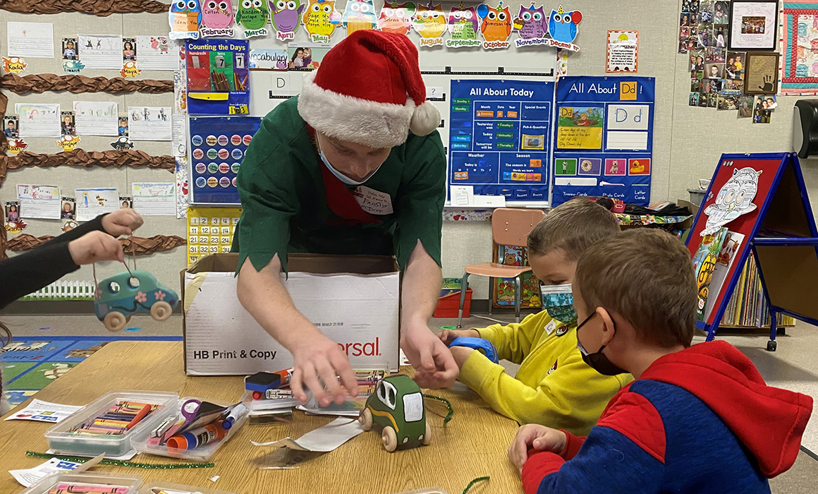 High school student dressed as elf gives toys to children