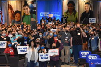 CTA members attending March 2022 State Council raise fists in support of Sacramento teachers.