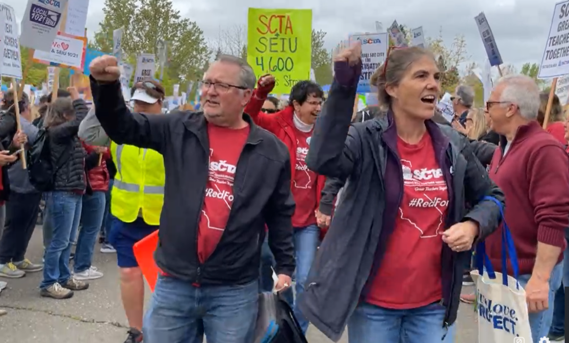 Educators raise their fists and march during the sixth day of the strike.