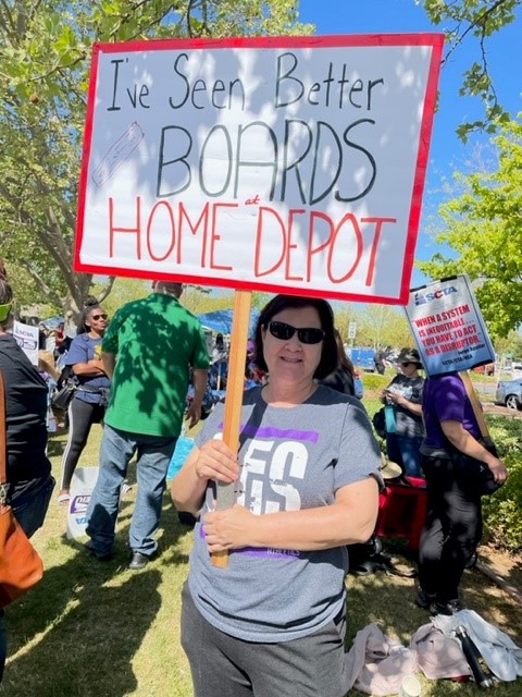 A-protester-at-the-strike-holds-a-sign-reading-Ive-seen-better-boards-at-home-depot