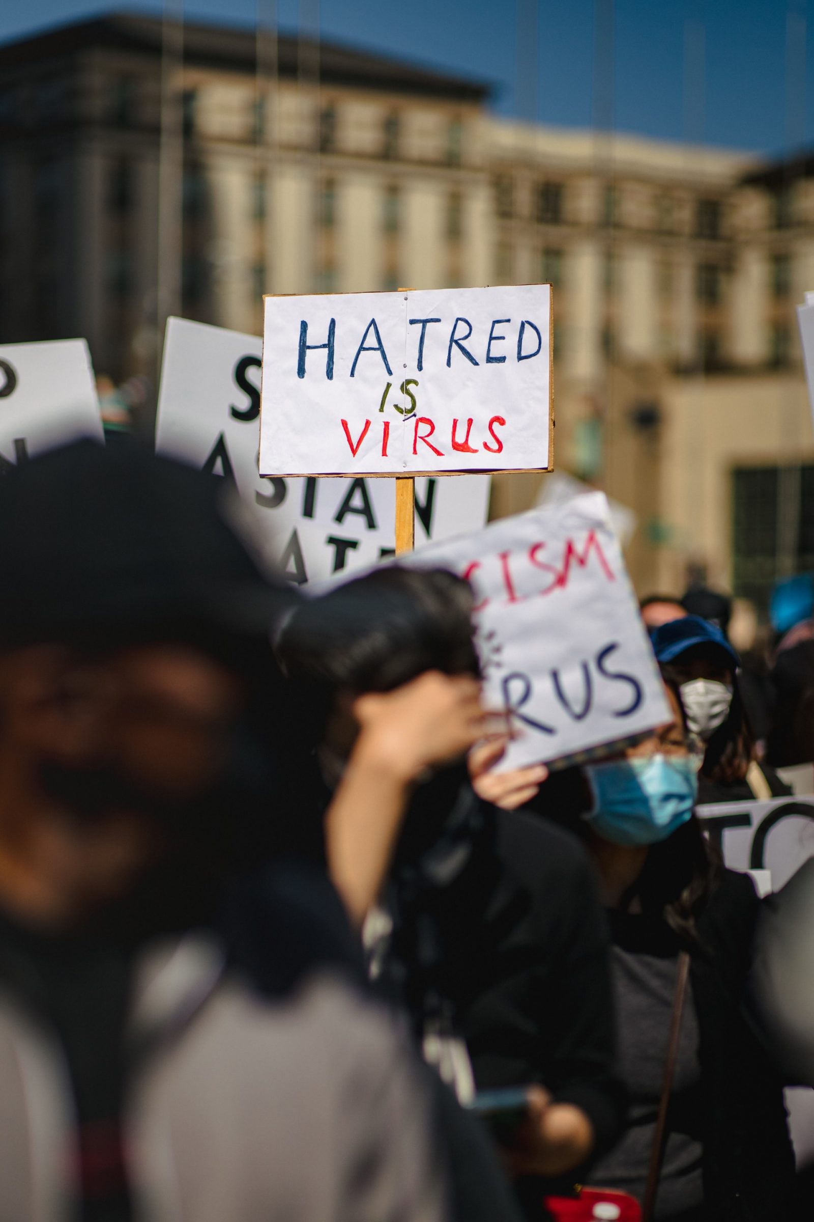 Protesters holding signs: HATRED IS VIRUS
