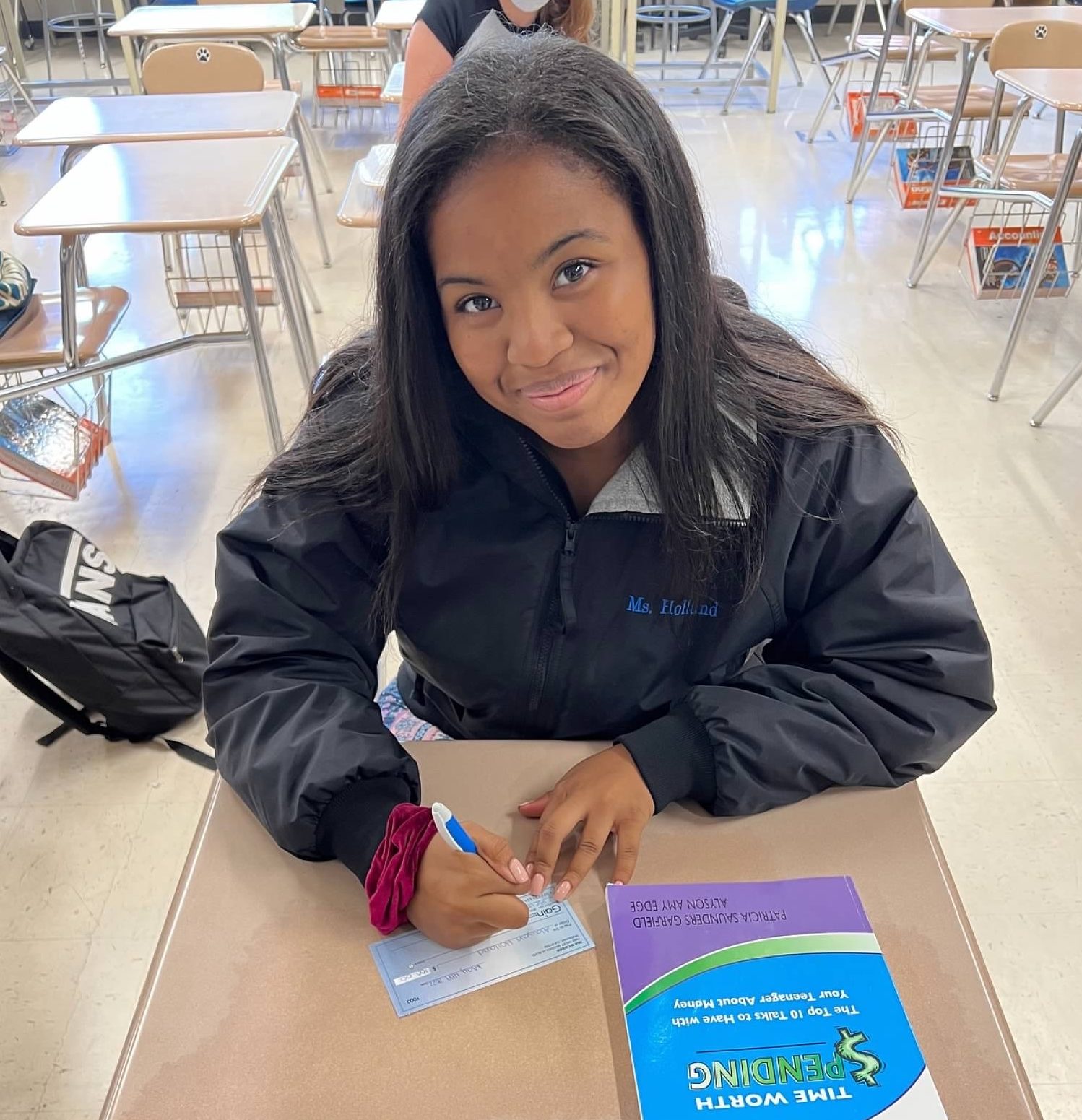 A student is sitting at the classroom table