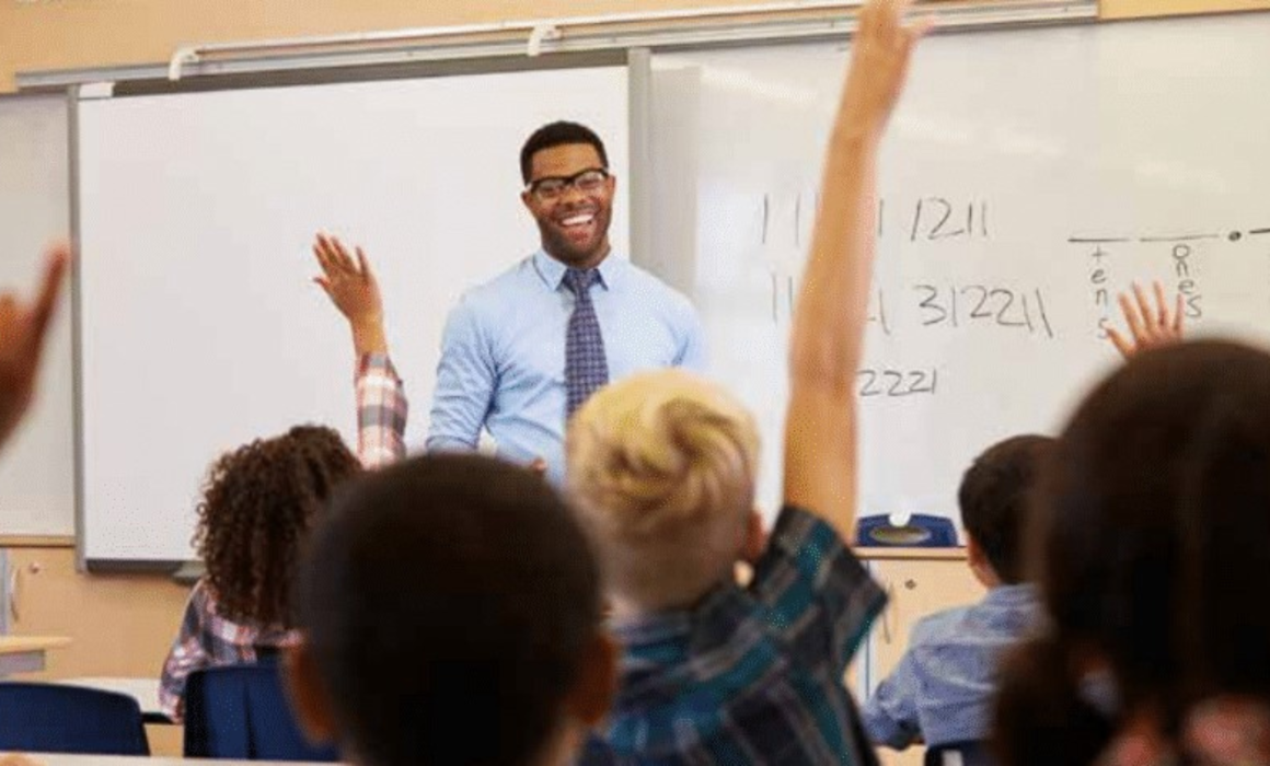 Picture of math teacher with students raising hands