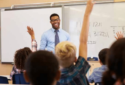 Picture of math teacher with students raising hands