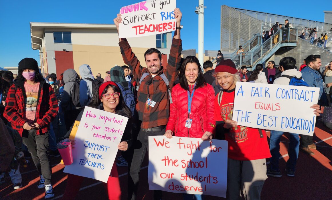 An image of United Teachers of Richmond members holding rally signs.