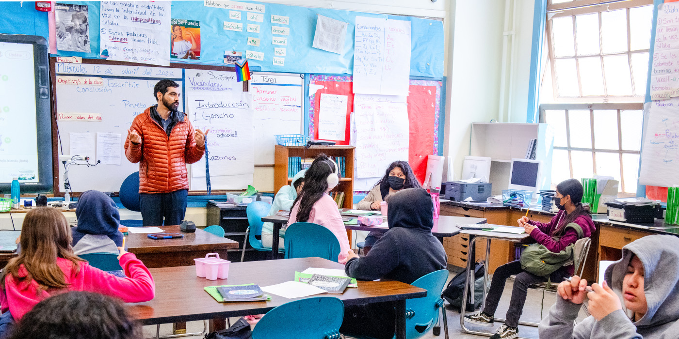 A teacher interacts with their students in a classroom.