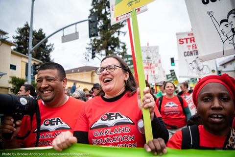 OEA President Ismael Armendariz, OEA member Olivia Udovic and others marching in the streets of Oakland. Photo credit: Brooke Anderson 