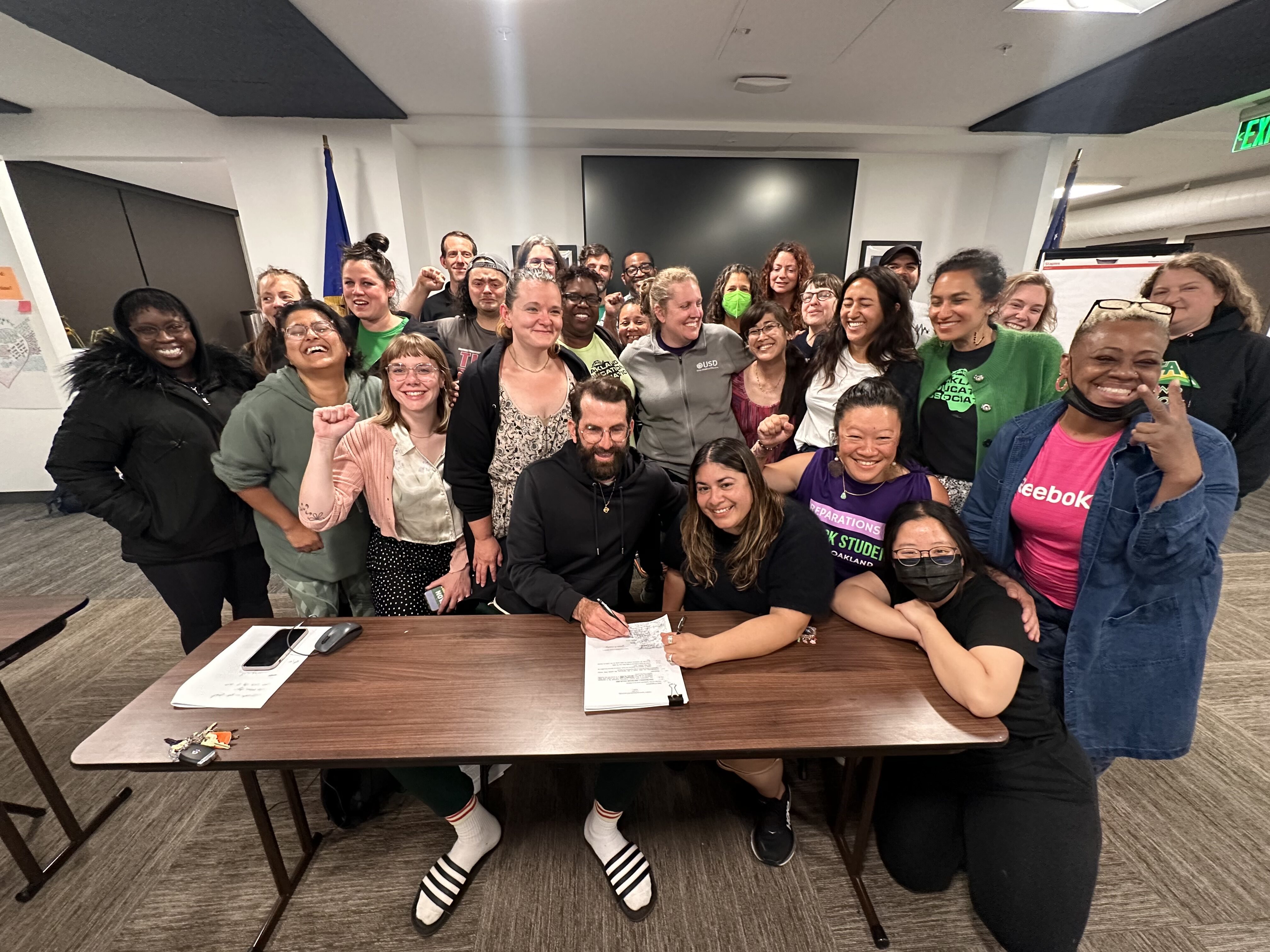 OEA’s bargaining team, led by Vilma Serrano and Timothy Douglas, signing their historic agreement at 3 o’clock in the morning.