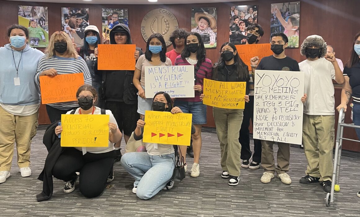 Protestors with signs about menstrual equity