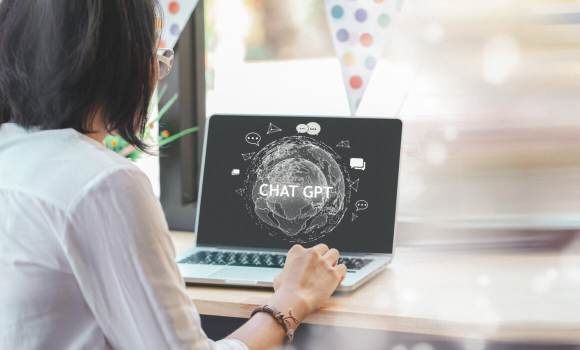 Photo of woman looking at laptop screen with ChatGPT