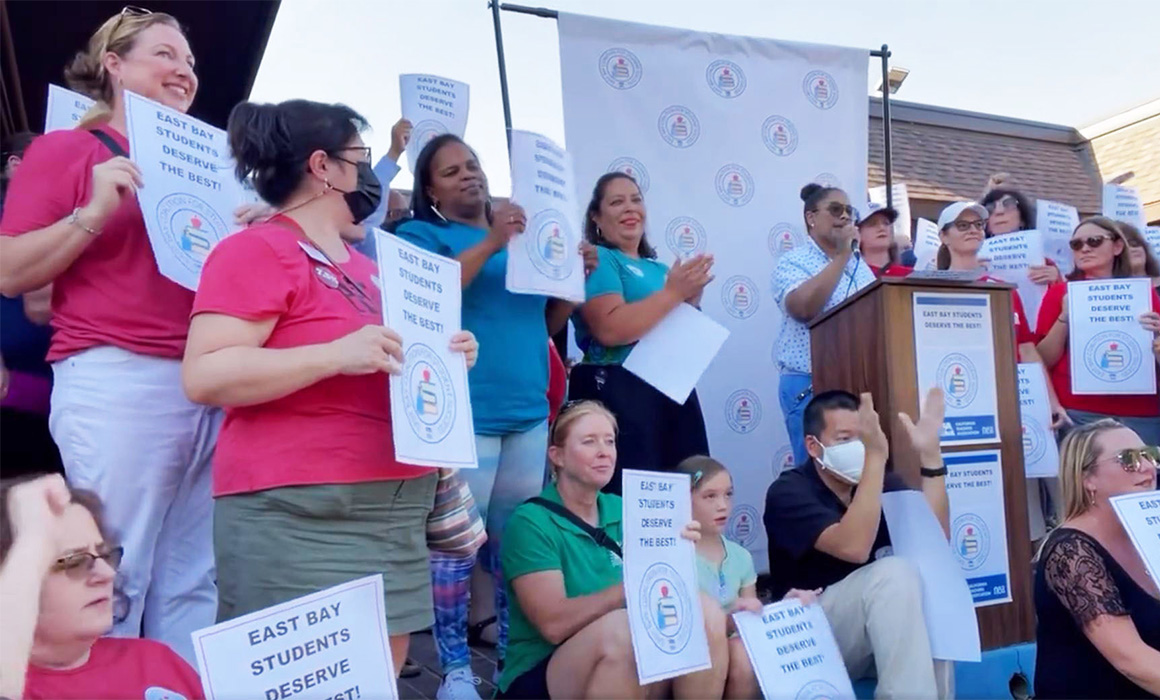 Image of teachers holding signs.