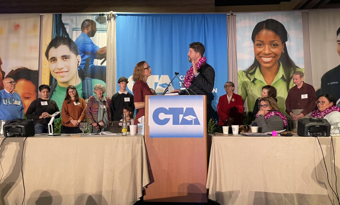 A photo of CTA President David Goldberg being sworn in to office while standing on stage in front of a podium displaying the CTA logo.