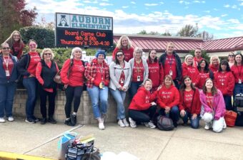 Auburn Elementary: Group of people in front of school sign.