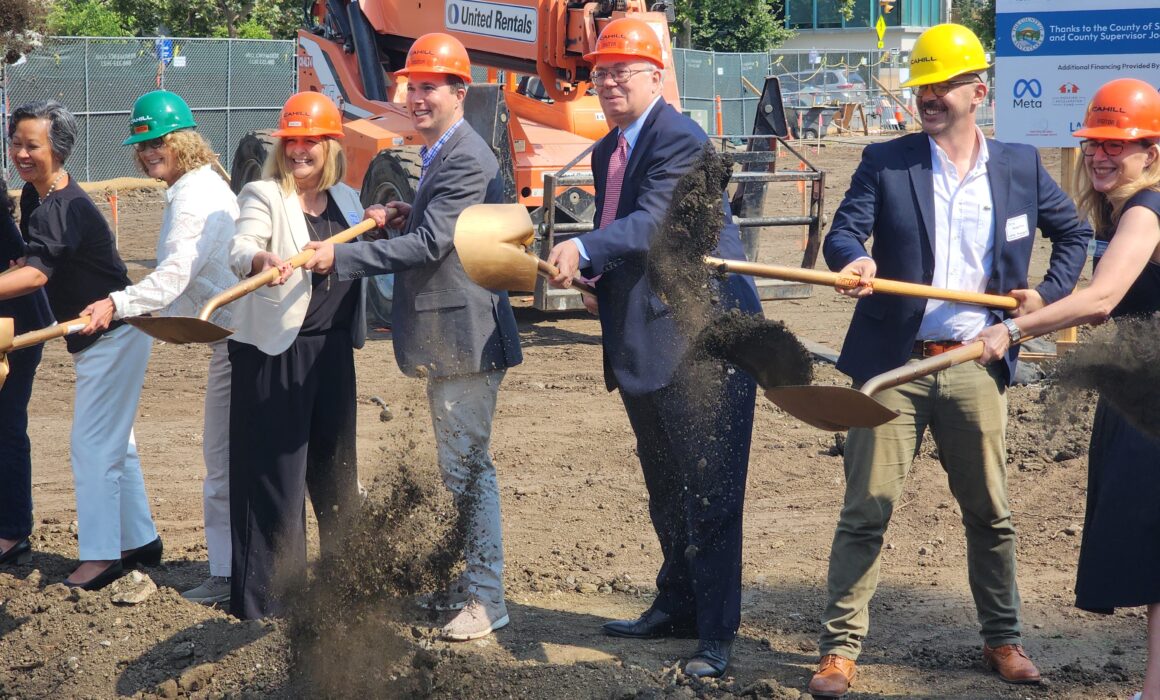 a group of people wearing orange hard hats