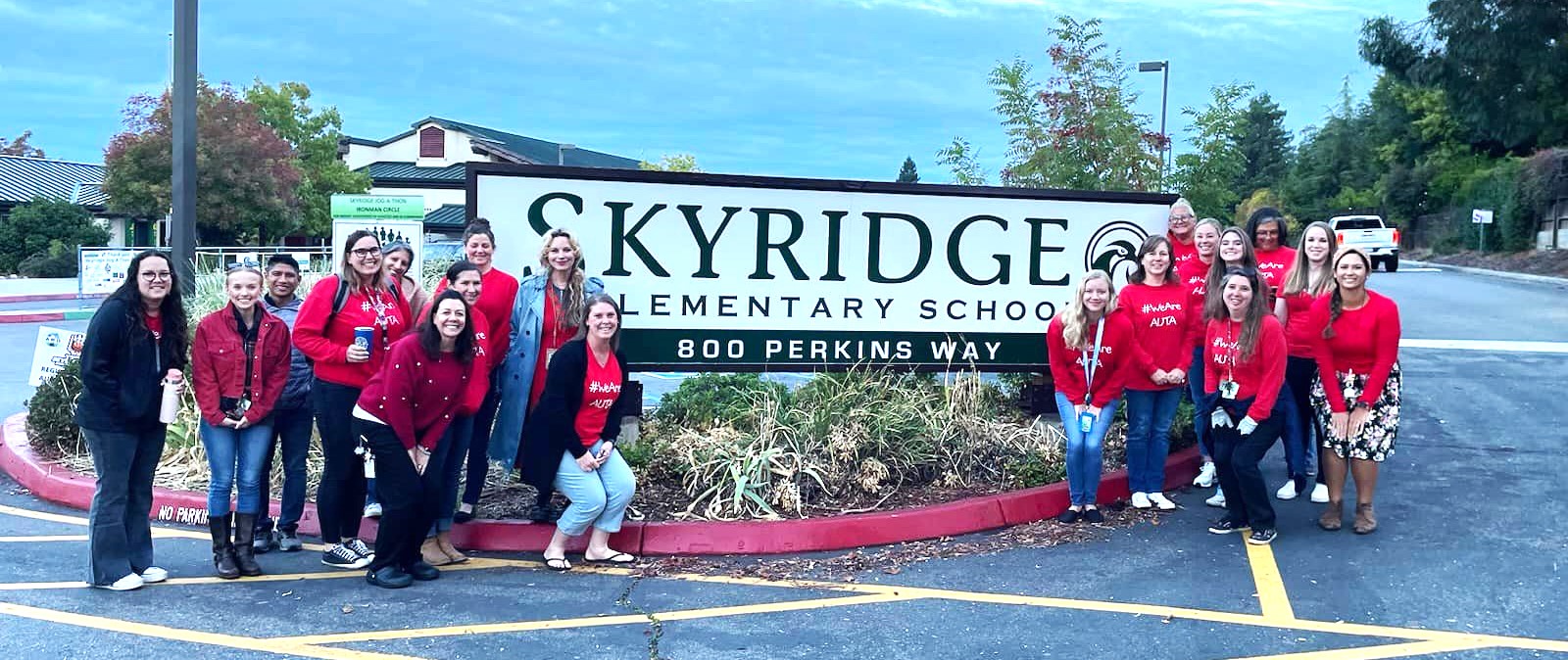 Skyridge Elementary: Group of people in front of school sign.