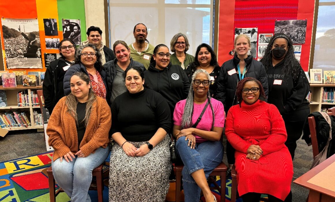 A group of people sitting and posing for a photograph. They belong to the West Contra Costa County Community Schools Support Collaborative