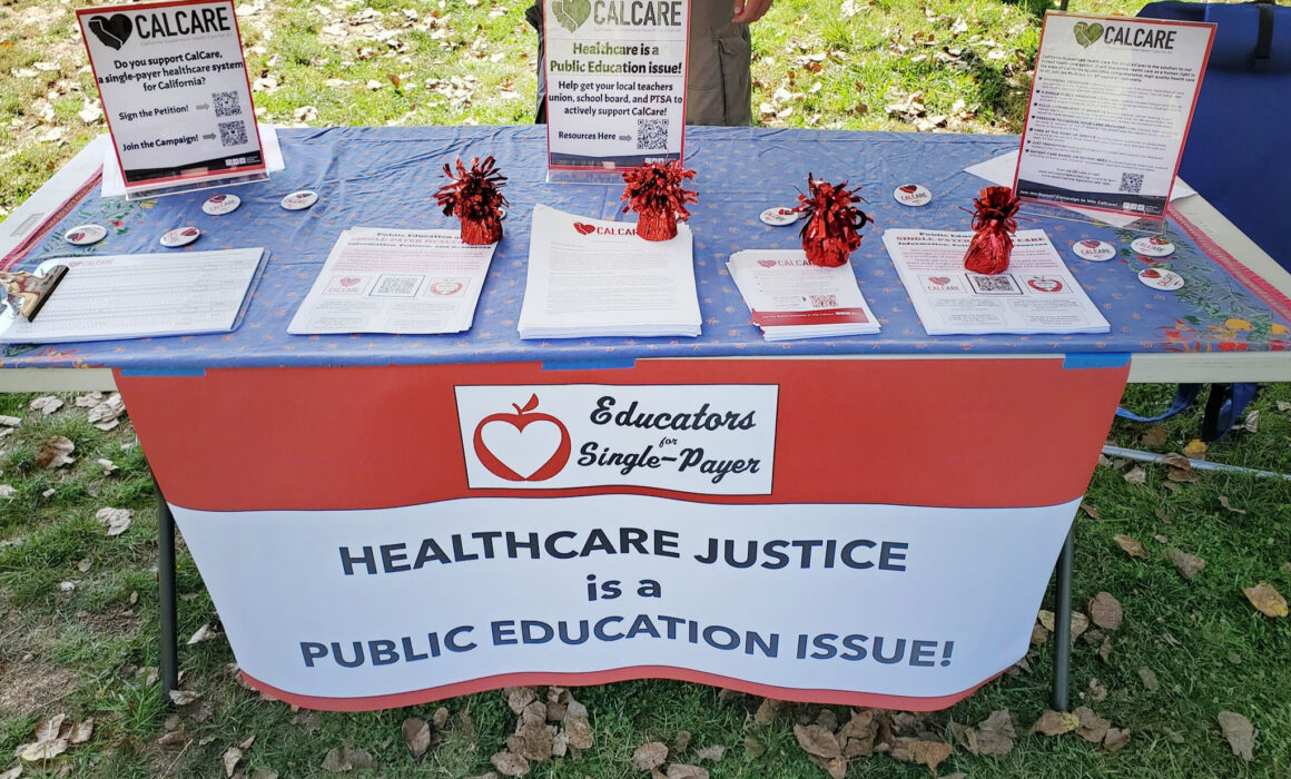 Photo of table with sign saying "Healthcare Justice is a Public Education Issue!"