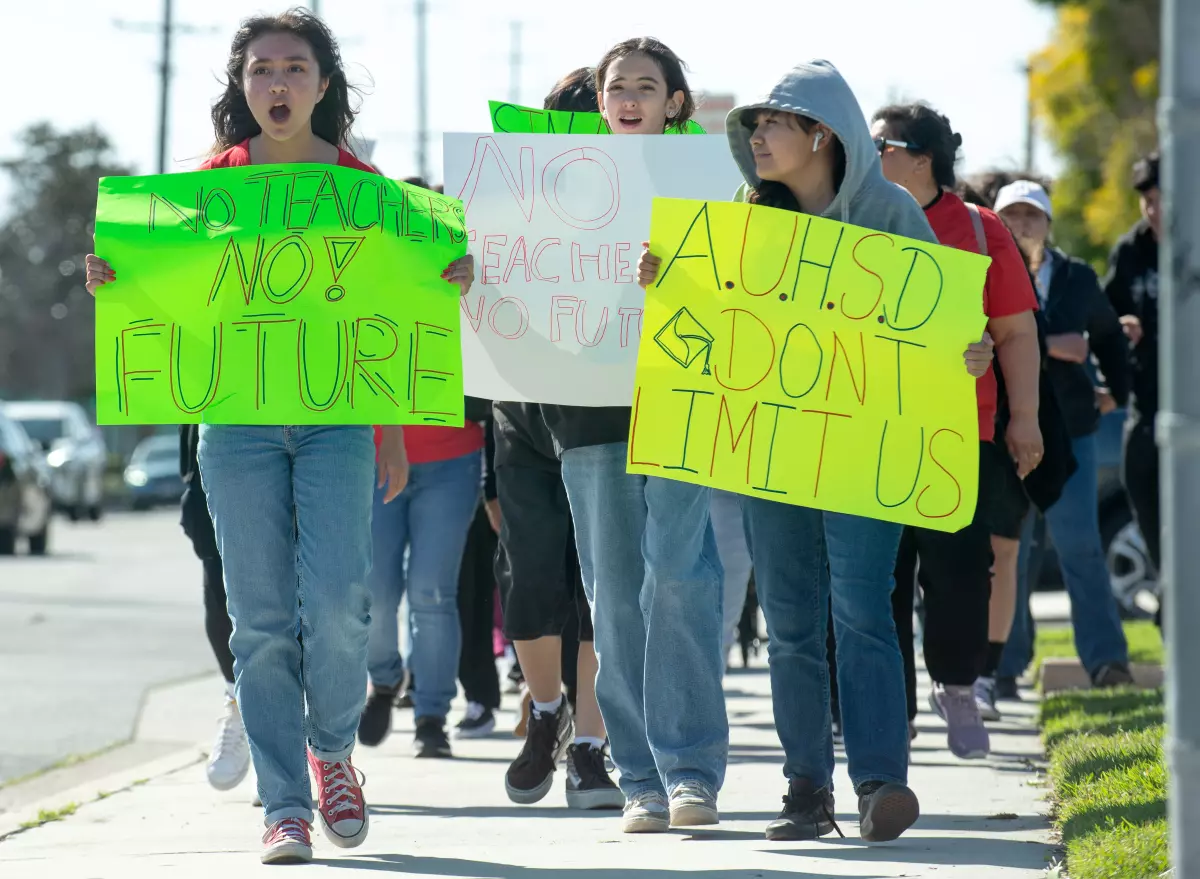 group of students marching and holding signs