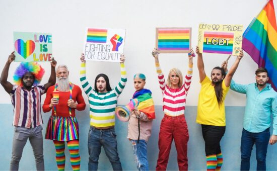 Photo of people holding LGBTQ+ advocacy signs.
